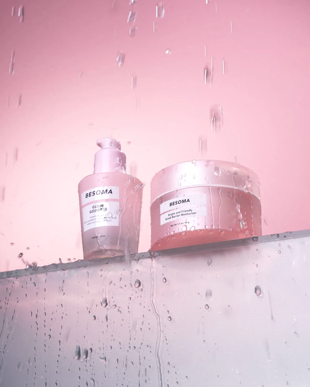 Soft pink skincare jars beaded with water